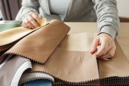 Female designer with fabric color samples choosing textile for curtainsの写真素材