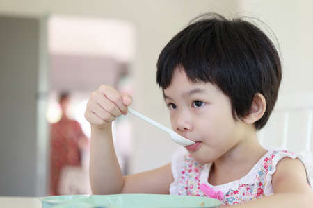 Little asian girl having breakfastの写真素材