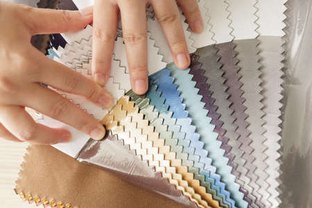 female designer with fabric color samples choosing textile for curtains