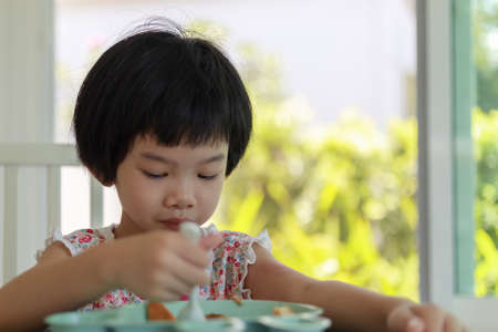 Little asian girl having breakfastの写真素材