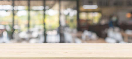 Empty wood table top with cafe restaurant interior blur backgroundの写真素材