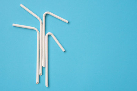 Biodegradable eco friendly white paper drinking straw on blue backgroundの写真素材