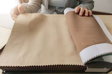 female designer with fabric color samples choosing textile for curtains