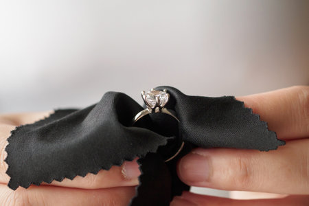 Jeweller cleaning jewelry diamond ring with fabric clothの写真素材