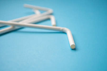 Biodegradable eco friendly white paper drinking straw on blue background