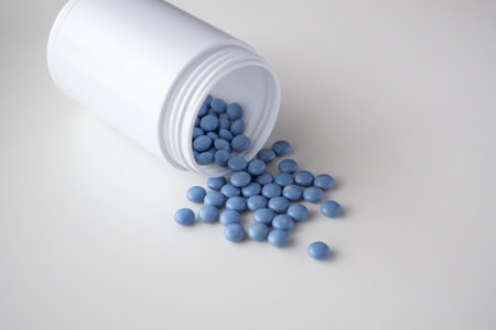 blue medicine pills with bottle on white backgroundの写真素材