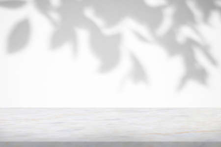 Marble table with tree shadow drop on white wall background for mockup product displayの写真素材