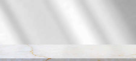 Marble table with window shadow drop on white wall background for mockup product displayの写真素材