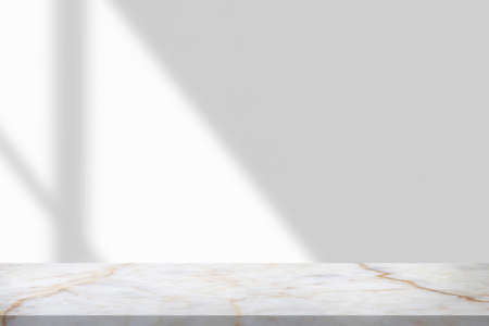 Marble table with window shadow drop on white wall background for mockup product displayの写真素材