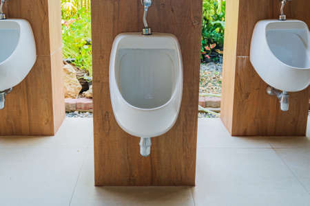 Modern men toilet room with white porcelain urinalsの写真素材