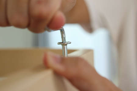 Assembly wooden furniture at home using screw allenの写真素材