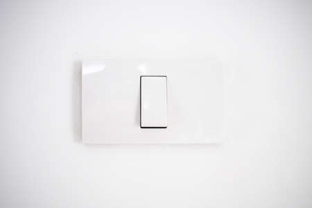 white lighting switch on concrete wall background