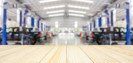 Empty wood table top with car service centre auto repair workshop blurred background