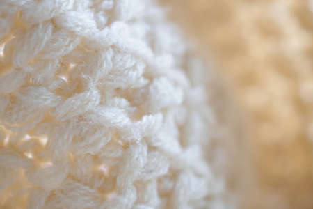 closeup beige knitted woolen fabric texture background