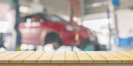 Empty wood table top with car service centre auto repair workshop blurred backgroundの写真素材