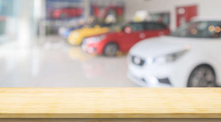 Empty wood table top with cars in showroom blurred defocused backgroundの写真素材