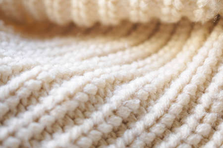closeup beige knitted woolen fabric texture background