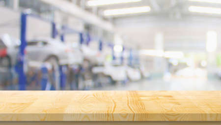 Empty wood table top with car service centre auto repair workshop blurred background