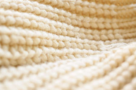 closeup beige knitted woolen fabric texture background