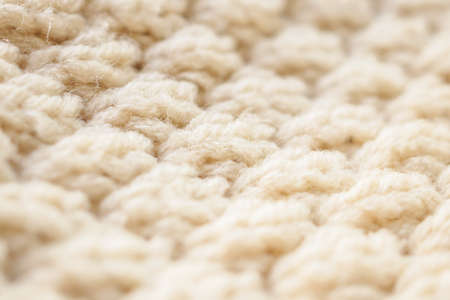 closeup beige knitted woolen fabric texture backgroundの写真素材