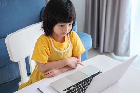 little asian girl student study online using laptop computer at homeの写真素材