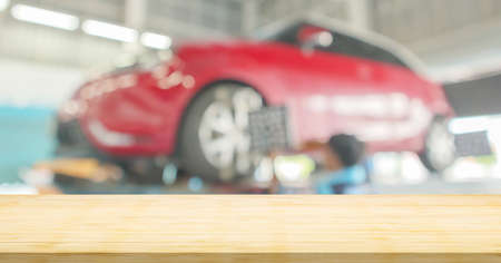 Empty wood table top with car service centre auto repair workshop blurred backgroundの写真素材