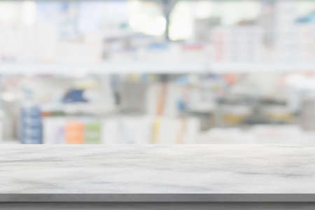 Empty white marble counter top with blur pharmacy drugstore shelves backgroundの写真素材