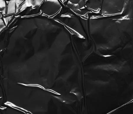 black crumpled and creased plastic poster texture background