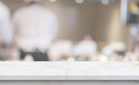 marble table top with blurred kitchen cafe restaurant interior backgroundの写真素材