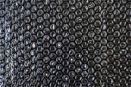 Plastic wrap air bubble packaging material on black background overlay texture