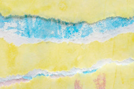 Abstract blue yellow watercolor paint on torn paper background textureの写真素材