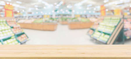 Wood table top with supermarket grocery store blurred defocused background with bokeh light for product displayの写真素材
