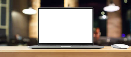 Laptop with blank screen on wood table with cafe coffee shop blur background