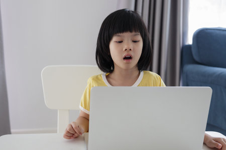 little asian girl student study online using laptop computer at home
