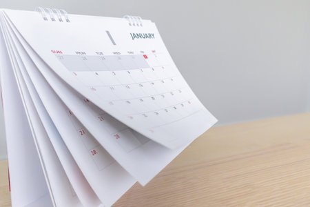 Calendar page flipping sheet on wood table background business schedule planning appointment meeting conceptの写真素材