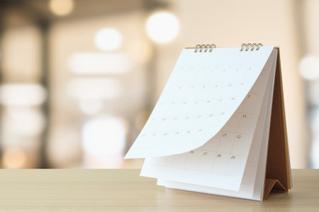 desk calendar on table with blurred bokeh background appointment and business meeting conceptの写真素材