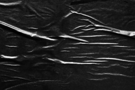 Black crumpled and creased paper poster texture backgroundの写真素材