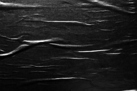 Black crumpled and creased paper poster texture backgroundの写真素材