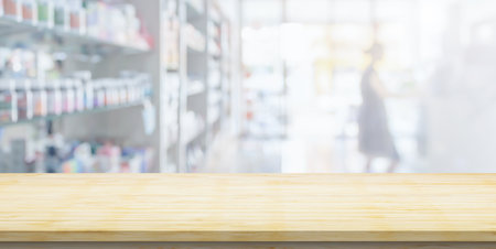 Empty wood counter top with blur pharmacy drugstore shelves backgroundの写真素材