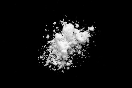 White snow isolated on black background close upの写真素材