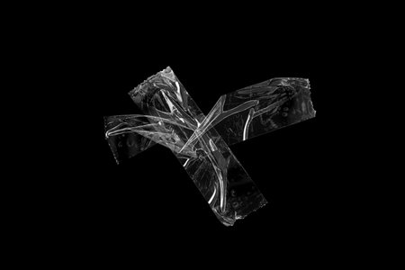 adhesive plastic tape isolated on black backgroundの写真素材
