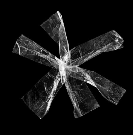 adhesive plastic tape isolated on black backgroundの写真素材