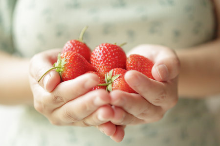 Woman hands holding fresh red strawberries close upの写真素材