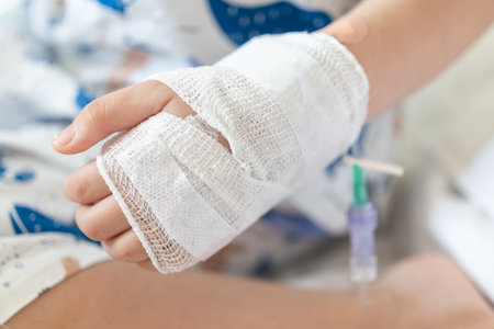 Close up child hand with saline IV solution in hospitalの写真素材