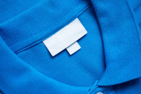 Blank white laundry care clothes label on blue shirt fabric texture backgroundの写真素材