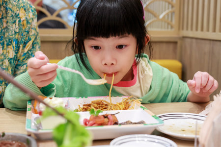 Cute little asian child girl eating foodの写真素材