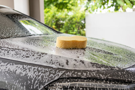 car cleaning and washing with yellow sponge and foam soapの写真素材