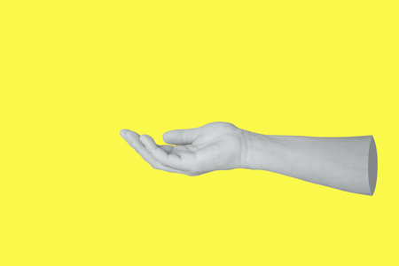 Woman hand gesture holding something isolated on yellow backgroundの写真素材