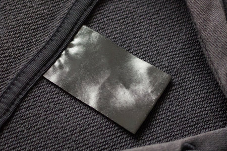 Blank black laundry care clothes label on black fabric texture backgroundの写真素材