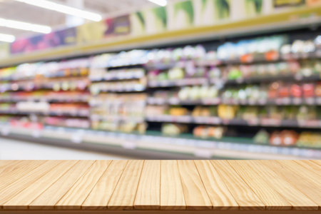 Empty wood table top with supermarket blurred background for product displayの写真素材